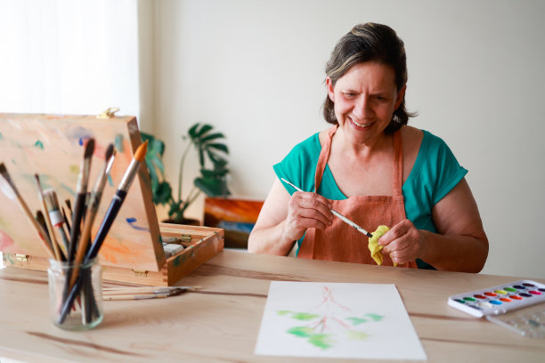 资深女艺术家在工作室画布上画水彩画-艺术商业和创意生活方式的概念图片下载