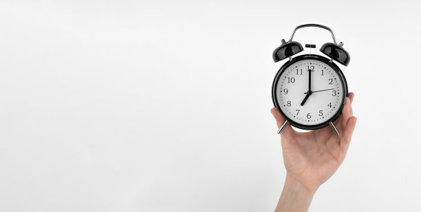 一个孤独的女人手里拿着一个黑色的闹钟图片下载