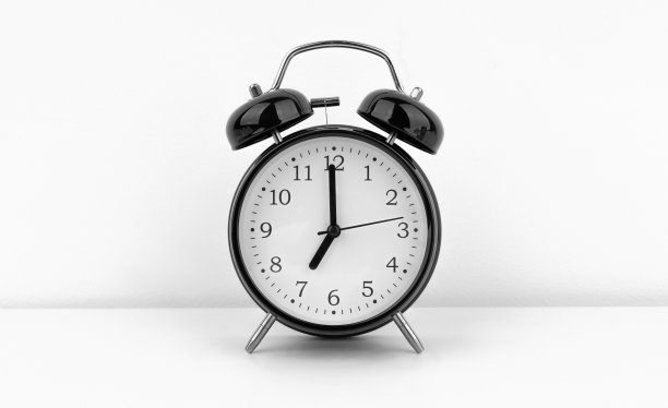 白色墙壁背景上的黑色闹钟图片下载