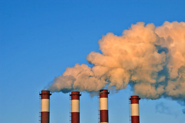 工业烟囱冒着白烟，映衬着蓝天。图片下载