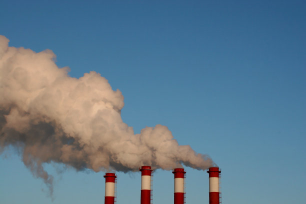 工业烟囱冒着白烟，映衬着蓝天。图片下载