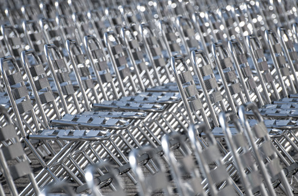 Empty metal chairs in the audience area. Outdoor event.图片下载