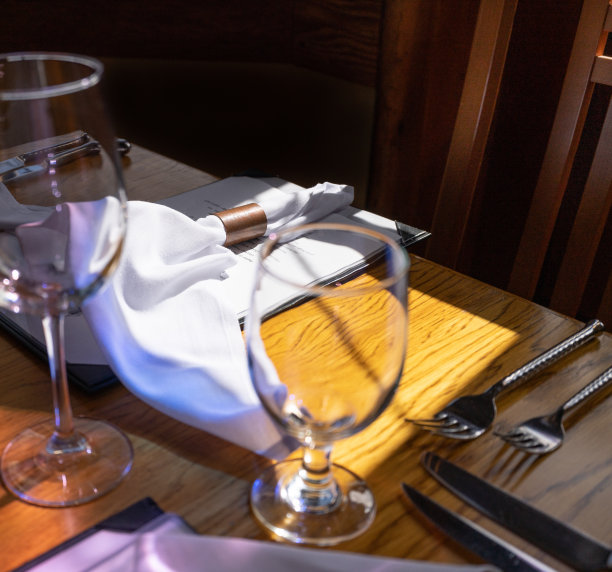 空酒杯、叉子和刀子在餐厅的木桌上特写图片下载