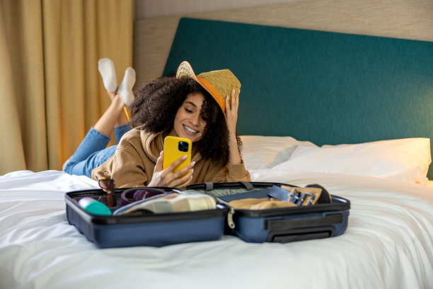Cute young woman making slefie on the bed in the hotel图片下载