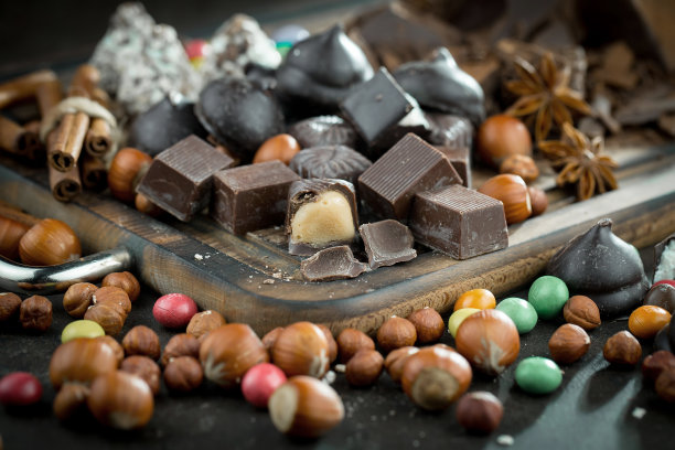 Chocolate, nuts, cocoa beans in a composition on an old background.图片下载