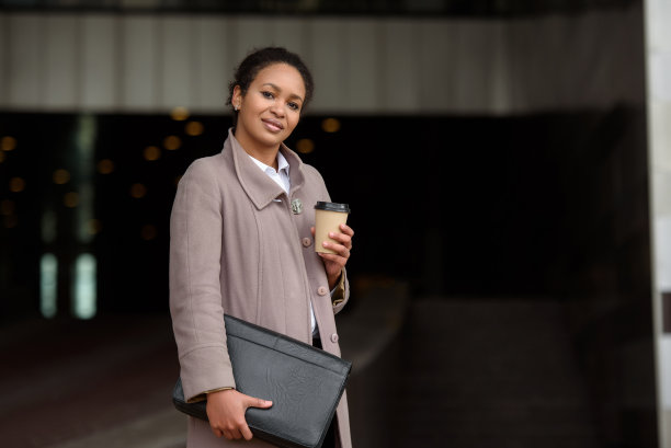 快乐的非裔美国女性穿着职业装带着文件和咖啡去办公室开会图片下载