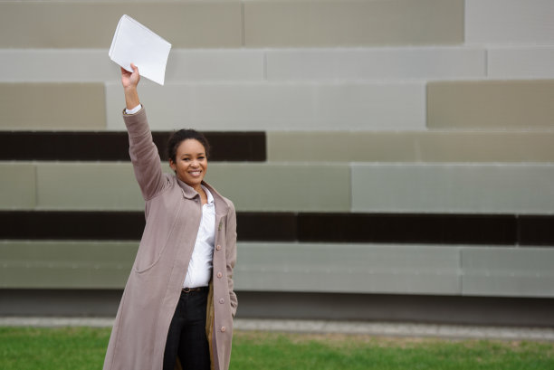 身着职业装的非裔美国女经理在城市风景的背景下为一笔交易感到高兴。本空间图片下载