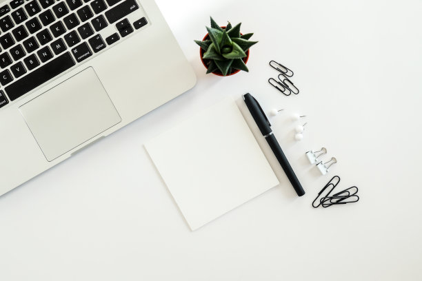 白色办公桌，配有空白笔记本、电脑键盘等办公用品。带复制空间的俯视图，平铺。图片下载