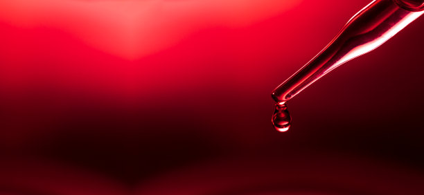 宏观科学实验移液器表面，红色背景下，化学液滴将油注入三个培养皿中的透明液体中。抽象护肤化妆品概念。图片下载