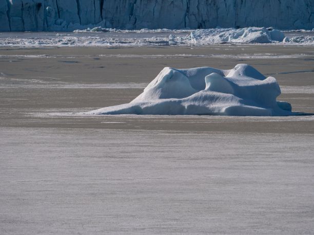 风景如画的冰山在水中，背景是白雪覆盖的山脉图片下载
