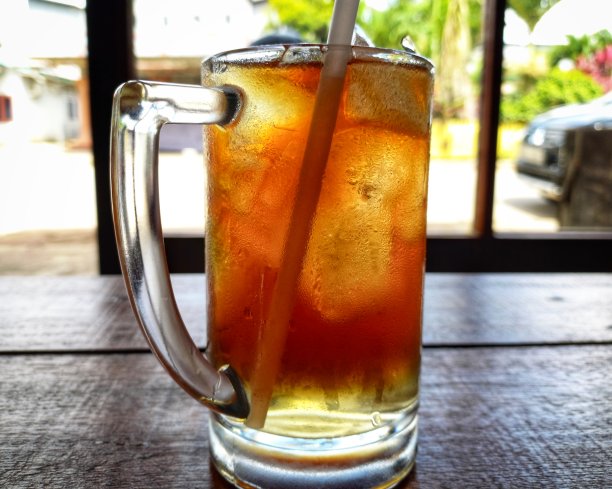 木桌上有一杯冰茶。图片下载