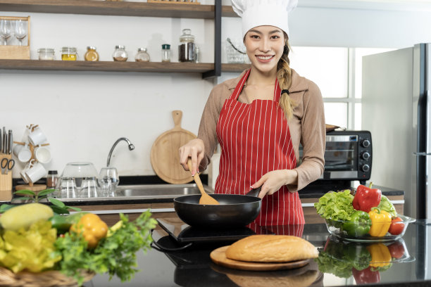 美丽的亚洲年轻女厨师在厨房准备健康的食物图片下载