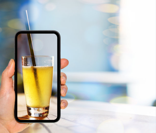 手机屏幕上的一杯柠檬水，拍摄咖啡馆里的饮料。图片下载