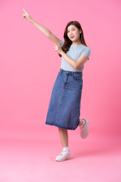 亚洲女孩在粉色背景上摆姿势图片下载