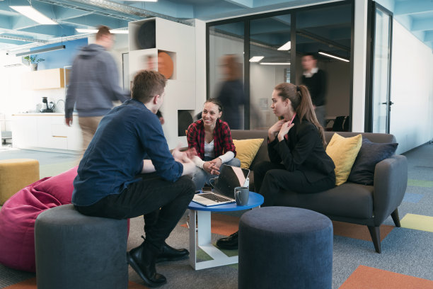 多民族创业团队在现代明亮的开放式办公空间开会。头脑风暴，在笔记本电脑上工作。一群同事在动态模糊中走来走去。图片下载