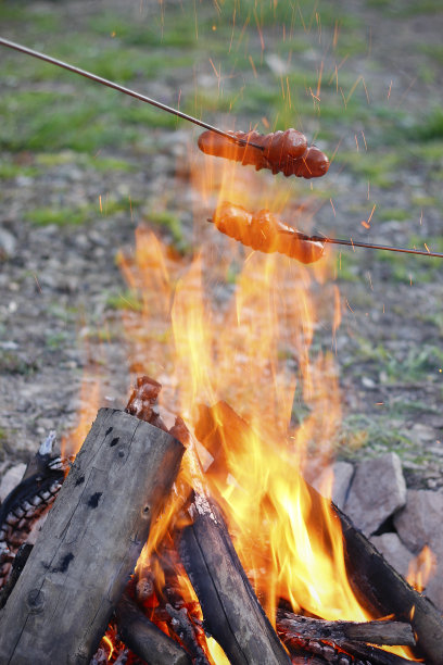 晚上在露天篝火上用烤叉烤香肠图片下载