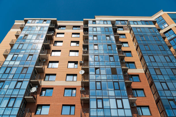 阳光明媚的日子里，蓝天下的现代公寓楼图片下载