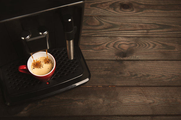 现代意式浓缩咖啡机，在厨房内部有一个杯子。煮新鲜咖啡的机器。特写。咖啡屋概念。放文字的地方。复制的地方。图片下载