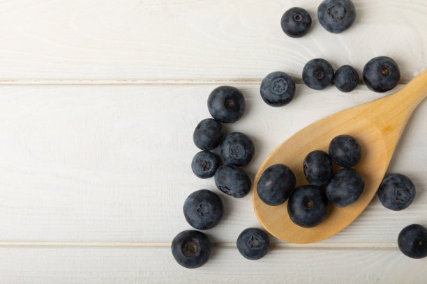 蓝莓。成熟和新鲜的蓝莓在白色的纹理背景下。维生素。健康食品。多汁的浆果。副本的空间。放文字的地方图片下载
