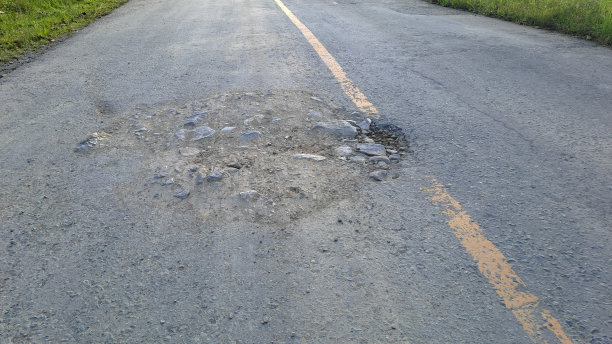 坑坑洼洼的沥青路面图片下载