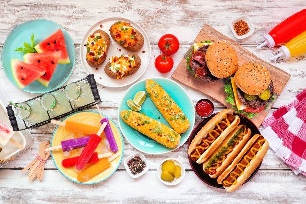 夏日烧烤餐桌上的汉堡和热狗在白色的木头上图片下载