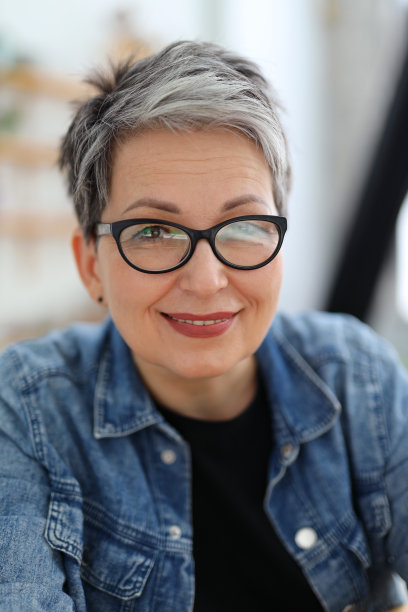 一个戴着眼镜的快乐的成熟女人的画像。图片下载