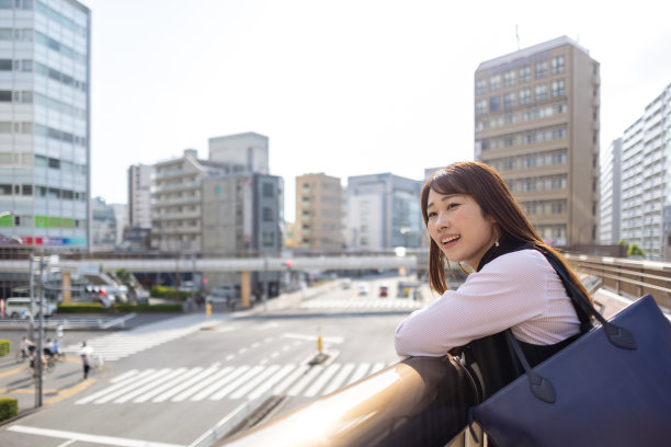 一位女商人在城市的人行天桥上看风景图片下载