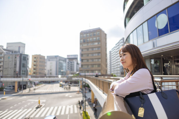 一位女商人在城市的人行天桥上看风景图片下载