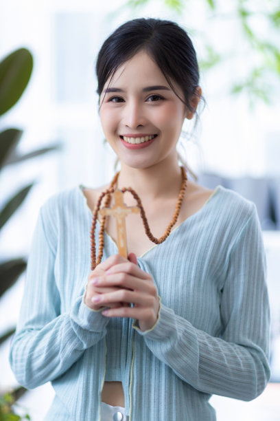 宗教观念中的女性。手握十字架向上帝祈祷。修女手里拿着十字架。人类的双手握着神圣的十字架，祈求上帝的祝福。图片下载