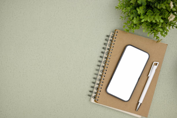 工作区顶部视图与智能手机模型和绿色背景的复制空间。图片下载