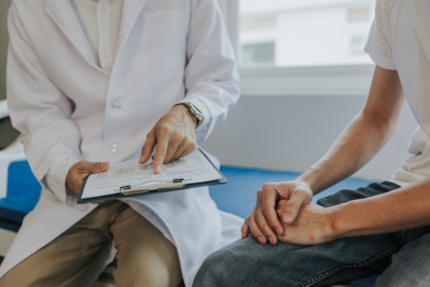 男性健康观念。那个疼痛的年轻人请医生治疗。医生正在和病人面谈并给他们建议。图片下载