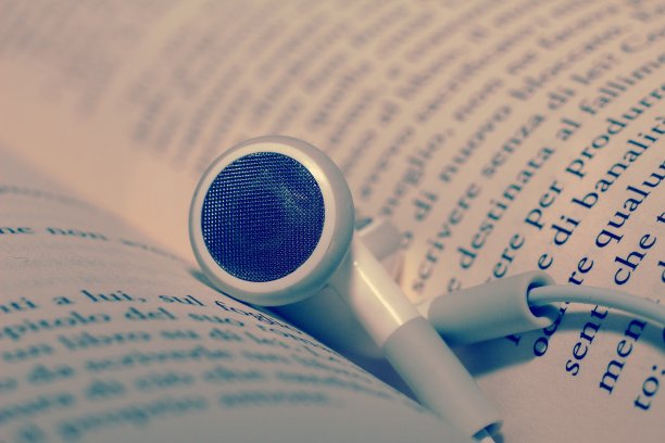 耳机在书中页面的宏观视图。有声书的概念。图片下载