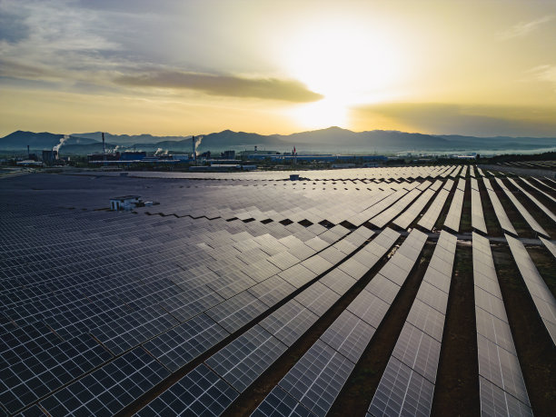 太阳能电池板农场(太阳能电池)与阳光鸟瞰图。无人机飞行在太阳能电池板领域，库存素材图片下载