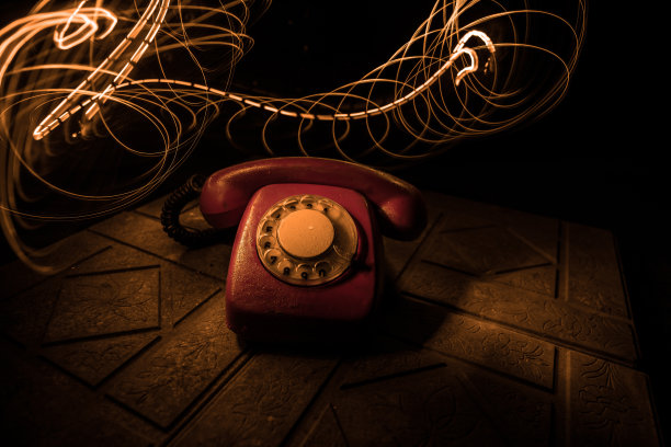 旧的黑色电话在旧木板与艺术黑暗背景与雾和色调的光。空的空间。图片下载