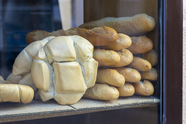 面包店柜台上有各种各样的面包。新鲜面包柜台图片下载