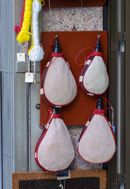 葡萄酒皮瓶，挂酒靴出售。传统的饮酒容器图片下载