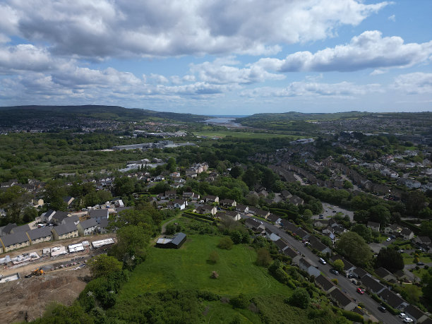 英国德文郡牛顿艾 Abbot：无人机航拍：绿带土地上的新建房屋建筑工地；城镇郊区的郊区庄园；远处的泰恩河和泰恩茅斯（照片 1）图片下载