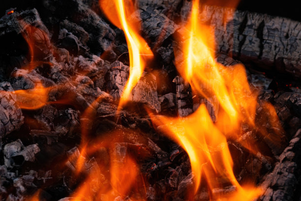 燃烧的火焰和烧焦的木柴。自然热能。图片下载