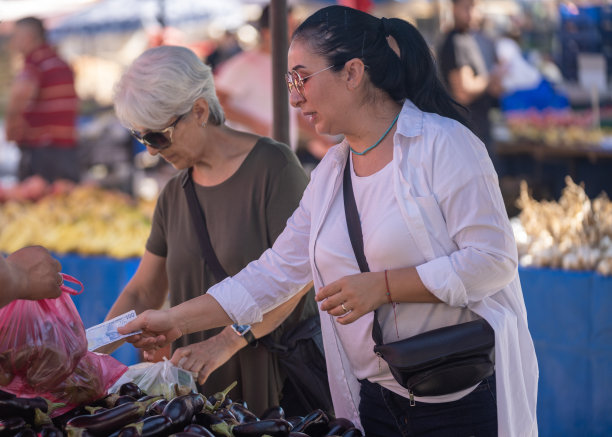 年长女性和朋友在农贸市场购物照片图片下载