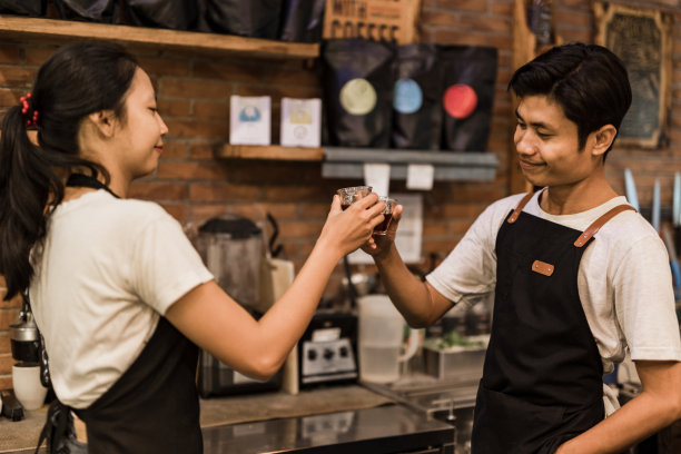 在巴厘岛一家传统咖啡馆工作的一名亚洲男子和一名女子。图片下载