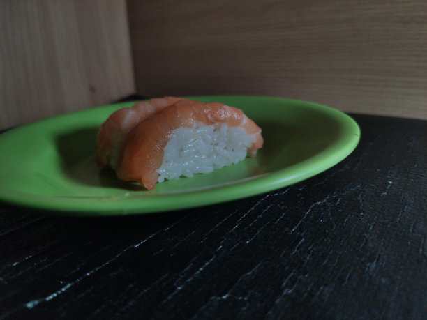 印尼街头小吃，绿色盘子里的生三文鱼和饭团图片下载