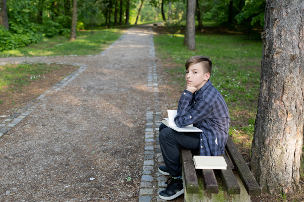 小学生在公园里看书图片下载