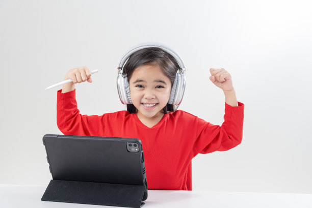 小女孩亚洲可爱戴上耳机，用笔记本电脑和老师视频通话，在电脑上在线学习，在家上学的概念图片下载