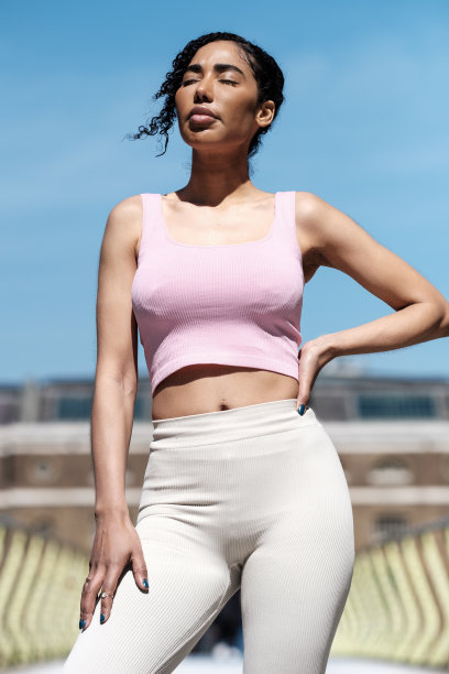 在一个阳光明媚的日子里，健身女人在桥上摆姿势。图片下载