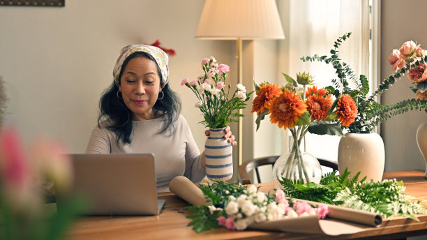 一位女花商正在家里通过网络制作在线插花工作坊。图片下载