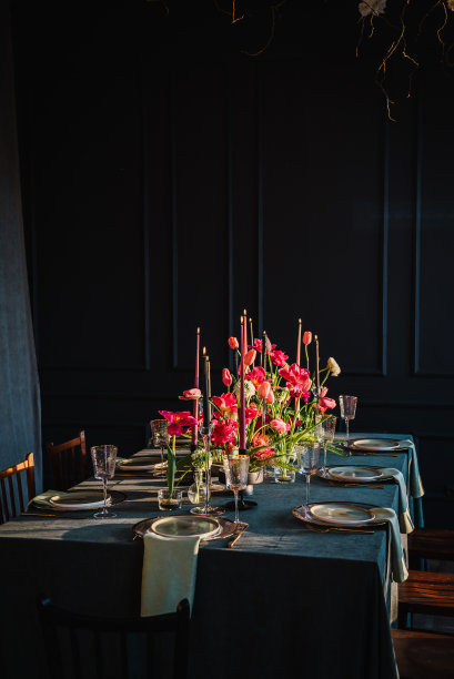 家庭度假在现代餐厅。时尚的春季派对。的婚礼。节日的餐桌上摆着盘子、餐具，用鲜花、郁金香和绿色植物、蜡烛装饰。生日庆祝活动。阳光图片下载