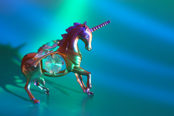蓝色背景的金属独角兽雕像。图片下载