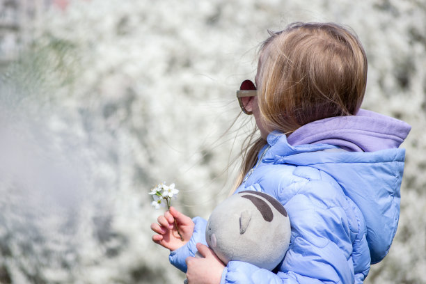 女孩站在盛开的树的背景上图片下载