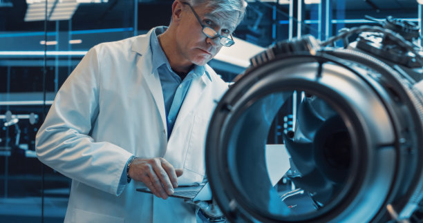 从事一项创新发明的中年工业涡轮机专家。科学家使用笔记本电脑开发高科技原型电动喷气发动机图片下载