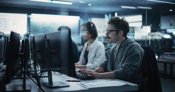 不同的年轻同事在研究实验室的计算机。一名女性向一名男性软件开发人员同事咨询他们合作的工业技术项目的解决方案图片下载